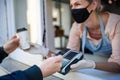 Woman with face mask serving coffee through window, shop open after lockdown. Royalty Free Stock Photo