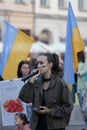 Woman with face paint speaking to microphone on an anti-war rally