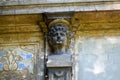 Woman face sculpture on the old weathered building facade.