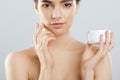 Woman Face Skin Care. Portrait Of Attractive Young Female Applying Cream And Holding Bottle. Royalty Free Stock Photo