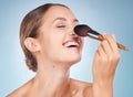 Woman, face and smile with makeup brush for skincare beauty, dermatology wellness and cosmetics treatment in blue Royalty Free Stock Photo