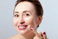 Woman face with Wrinkles and cosmetic cream close up . Collagen and anti aging concept.