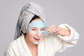 Woman with facial clay mask at spa salon or at home, skincare theme. Girl removes alginate cosmetic mask. Face mask, spa