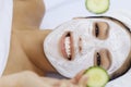 Woman with facial mask holding cucumber slices Royalty Free Stock Photo