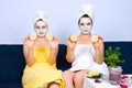 Woman with facial mask showing slices lemon