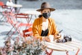 Woman in facial protective mask at the cafe outdoors Royalty Free Stock Photo