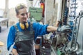 Woman in factory grabbing tool from wall mount