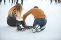 woman fall down while skating. man helping her Royalty Free Stock Photo