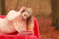 Woman in fall park with tablet browsing internet. Royalty Free Stock Photo