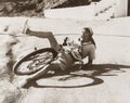 Woman falling off her bicycle on side of road Royalty Free Stock Photo