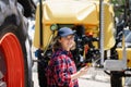 Woman farmer with a digital tablet on the background of an agricultural tractor Royalty Free Stock Photo