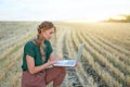 Woman farmer smart farming standing farmland smiling using laptop Female agronomist specialist research monitoring analysis data Royalty Free Stock Photo