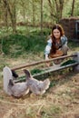 Woman farmer smiles feeds birds chickens organic food for bird health and good eggs and care for the environment, sunset Royalty Free Stock Photo