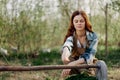 A woman farmer smiles and pours food for the birds into a bird feeder from a bowl at an outdoor farm to raise healthy Royalty Free Stock Photo