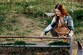 Woman farmer smiles and pours food for the birds at the bird feeder at the chicken farm Royalty Free Stock Photo