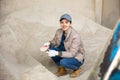 Woman farmer squatting at heap of corn flour