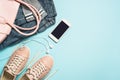 Woman fashion cloth set pink shoes, jeans, handbag, smartphone and perfume on blue background. Royalty Free Stock Photo