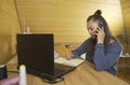 Woman fashion designer working on a laptop, making notes in a notebook Royalty Free Stock Photo