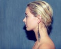 Woman, fashion and earring in stylish profile, feather and trendy or retro, aesthetic and cool. Female person, hipster
