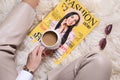 Woman with fashion magazine and cup of coffee sitting on floor, top view Royalty Free Stock Photo