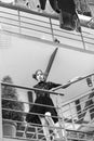 Woman standing high on metallic, green, house stairs