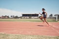 Woman, fast runner and sports on stadium track for marathon training or exercise wellness. Athlete person, motion blur