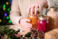 Woman Fastening Lids On Homemade Jars Of Preserved Fruit For Eco Friendly Christmas Gift