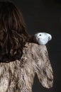 Woman in feathers with pigeon on shoulder