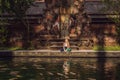 Woman feeding beautiful coloured fish in pond temple on Bali