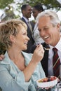 Woman Feeding Fruit Salad To Man