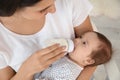 Woman feeding her baby from bottle at home Royalty Free Stock Photo