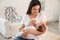 Woman feeding her baby from bottle in nursery Royalty Free Stock Photo
