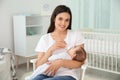 Woman feeding her baby from bottle in nursery Royalty Free Stock Photo