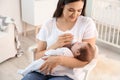 Woman feeding her baby from bottle in nursery Royalty Free Stock Photo