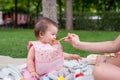 woman feeding her beautiful little daughter - mother hand and close up portrait of adorable and happy baby girl eating baby Royalty Free Stock Photo