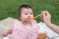 woman feeding her beautiful little daughter - mother hand and close up portrait of adorable and happy baby girl eating baby Royalty Free Stock Photo