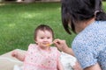 woman feeding her beautiful little daughter - mother hand and close up portrait of adorable and happy baby girl eating baby Royalty Free Stock Photo