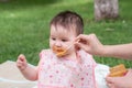 woman feeding her beautiful little daughter - mother hand and close up portrait of adorable and happy baby girl eating baby Royalty Free Stock Photo