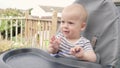 Woman feeding Tired child with spoon. Mom feed crying Sad baby Boy with pureed food. Mom feeding kid in baby chair Royalty Free Stock Photo