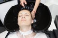 Woman feel relax and comfortable while getting hair wash with shampoo and massage in beauty salon Royalty Free Stock Photo