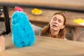 Woman feeling awful dusting the shelves and having allergy