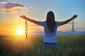 Woman feeling free in a beautiful natural setting, in what field at sunset. Free from chains Royalty Free Stock Photo