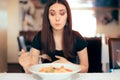 Woman Feeling Sick While Eating Bad Food in a Restaurant Royalty Free Stock Photo