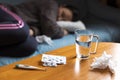 Woman feeling sick lying on sofa and have some medications on table