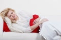 Woman feeling stomach cramps lying on cofa