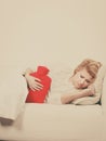 Woman feeling stomach cramps lying on cofa Royalty Free Stock Photo