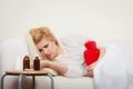 Woman feeling stomach cramps lying on cofa Royalty Free Stock Photo