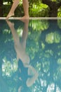 Woman Feeling The Water Temperature By Poolside