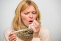 Woman feels badly ill sneezing. Girl in scarf hold thermometer and tissue close up. Cold and flu remedies. Take Royalty Free Stock Photo