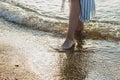 Woman feet in barefoot touched by gentle sea surf waves on sand beach Royalty Free Stock Photo